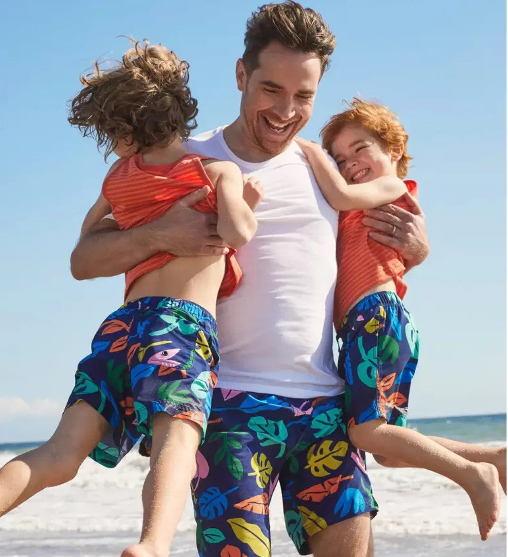 Sublimare fabric for sublimation Man with two children on a beach wearing colorful swim trunks.